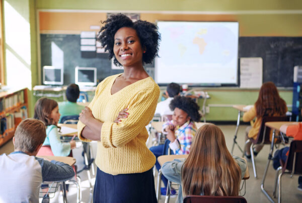 teacher smiling in classroom - develop teacher expertise concept